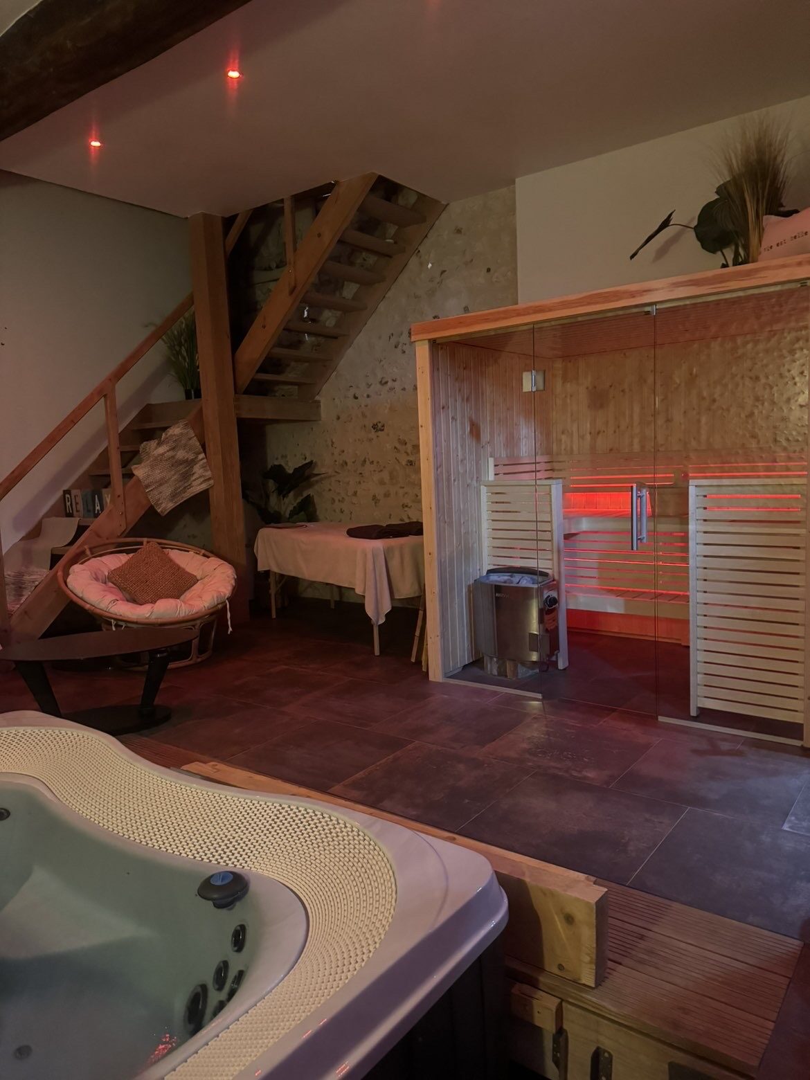 Espace bien-être privatisé de la love room Ba'cam Spa à Etigny : spa, sauna et table de massage